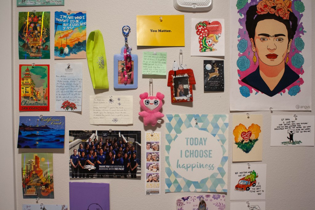A wide shot of a decorated wall including art prints, photos, and other small items